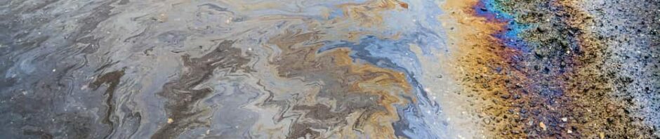 Oil gleaming with rainbow hues in contaminated water.